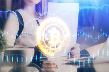 Cryptocurrency hologram over woman's hands writing background. Concept of blockchain. Double...