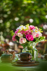 Naklejka na ściany i meble Summer flower bouquet on a garden table