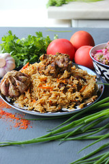 Pilaf on a platter of meat and spices.pilaf in a plate on a wooden background, top view.  The concept of Oriental cuisine. Homemade Uzbek pilaf of lamb is served in cast iron cookware. Copy space.