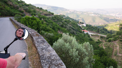 Motorcyclist rides on a serpentine road of the Douro Valley, Porto, Portugal.