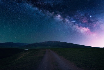 Naklejka na ściany i meble Beautiful night landscape. Starry sky with milky way galaxy over the road and Aragats mountain. Armenia.
