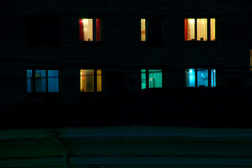 Glowing apartment windows at night where each occupant has his own privacy