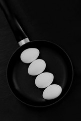  black pan with raw eggs on a black