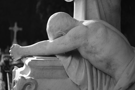 estatuta de hombre sobre tumba. Lamento, f&uacute;nebre en blanco y negro