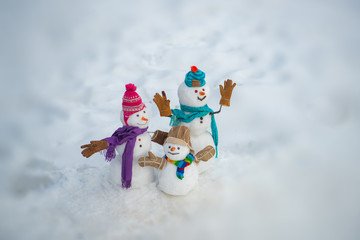 New Year banner. Funny group of snowmen family in stylish hat and scarf on snowy field. New Year...