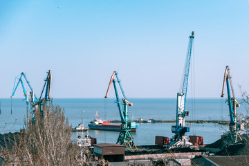 working cranes in a small port in sunny weather. beautiful multi-colored cranes in a small port.