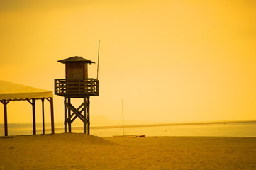 Fototapeta na wymiar A lifeguard tower in a deserted beach of Huelva on a hot sunny day of summer, Spain 