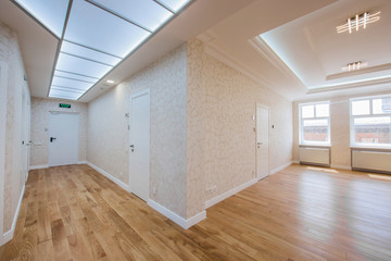 office corridor with rooms for reception of guests without furniture with wide windows and wooden floor, the interior is made in bright colors