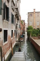 Fototapeta na wymiar Side canal in Venice with small boats