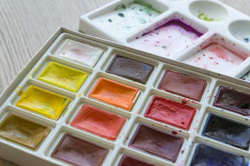 Creative artistic education concept - the box with the set of colorful watercolor paint close up