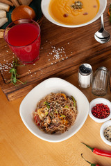 Thai noodles with vegetables, roasted chicken and sesame, flavoured with oyster sauce on wooden table with ingredients on it