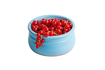 Ripe red currants in a blue ceramic cup on a white isolated background
