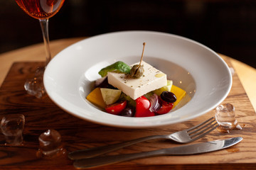 Greek vegetable salad with a huge chunk of feta cheese for diet dinner indoors