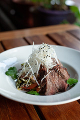 Rustic style salad with roasted pork, greens and grated turnip