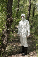 full length view of ecologist in protective costume and respirator in forest