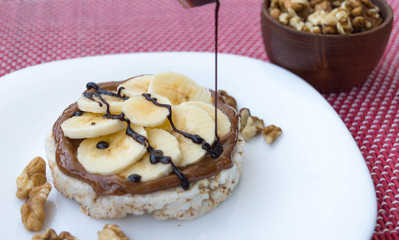 Rice biscuit with dulce de leche and pieces of banana and nuts. Accompanied with a milk banana smoothie. Added low calorie chocolate.