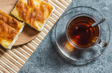 Turkish su boregi, burek or borek, turkish water patty slices with cheese and turkish tea, traditional turkish stuffed filo dough cheesy pastry food