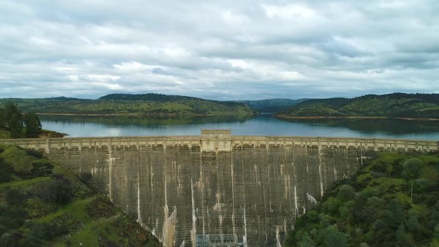 Aerial View  Dam Village waterfront  4K Helicopter Shot  landmark trees road cars cloudes california lake