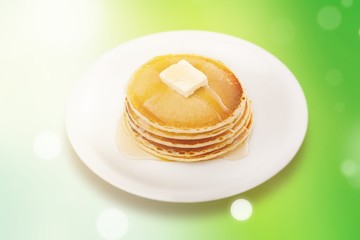 Stack of Small pancakes in syrup on background