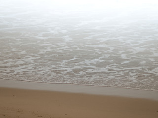 Water and sand of a foggy shoreline