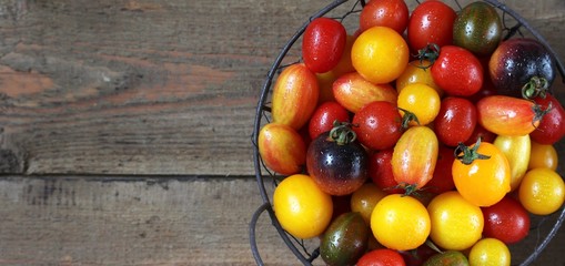cherry tomatoes are different varieties in the basket, small tomatoes of different colors and types.