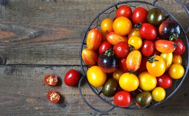 cherry tomatoes are different varieties in the basket, small tomatoes of different colors and types.