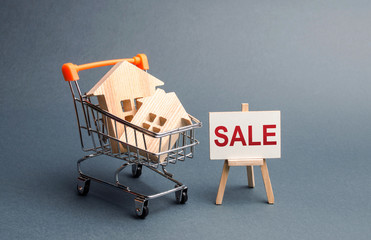 Two houses in a shopping cart and a stand with the inscription sale. selling a home. Announcement...