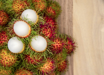 Many fresh rambutans are placed on the old wood