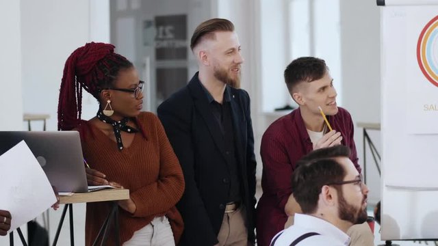 Happy smiling attentive multiethnic business people work together, listen to discussion during modern office meeting.