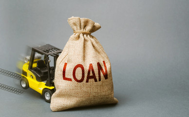 Yellow forklift truck crashed into the bag with the word loan and can not lift it. Inability to...