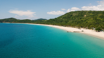 Aerial view of Nacpan Beach, tropical beach in El Nido with palm trees and chystal water