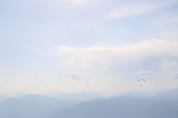 paraglider in the sky with mountains behind