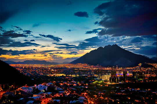 city at night below the mointains