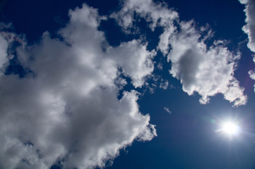 Naklejka na ściany i meble white fluffy clouds in the blue sky on a sunny summer day