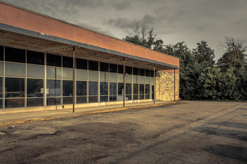 Fototapeta na wymiar Long row of tall windows of an older brick office building sitting empty in midwestern suburb