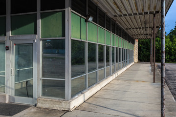 Tall windows with green tint on upper windows of Long row of tall windows of an older brick office building sitting empty