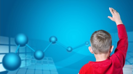 Boy studying subject at school, back view, blackboard background.