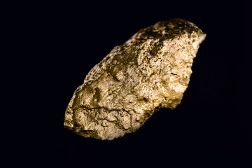 Nugget of gold, stone of value, golden texture. Crude gold mined. Concept of wealth and financial stability.