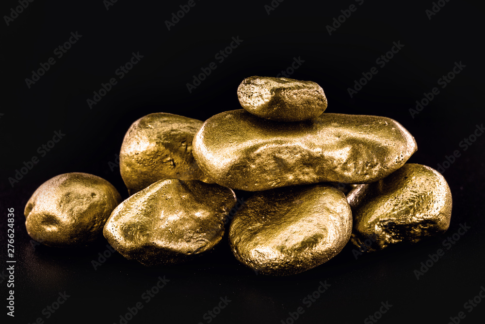 Wall mural Gold nugget, large gold stone closeup isolated on black background. Concept of finance, luxury or wealth.