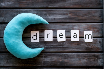 Dream word and moon for sleep concept on wooden background top view