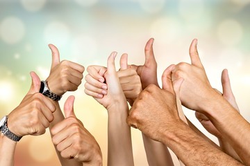 Group of people hands showing thumbs up signs on background