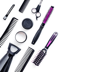 Combs, sciccors and pink hairdresser tools in beauty salon work desk on white background top view space for text
