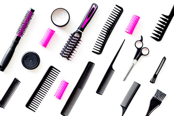 Combs, sciccors and pink hairdresser tools in beauty salon work desk on white background top view...