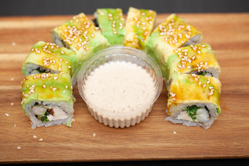 Sushi roll with salmon, cheese and avocado.