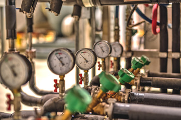 Gauge closeup, pressure measurement . Pipes and valves in the industrial enterprise.