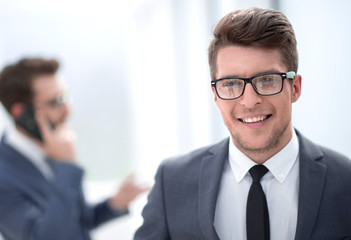 close up.smiling young businessman in the office background