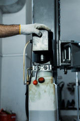 cropped view of car mechanic in car repair station