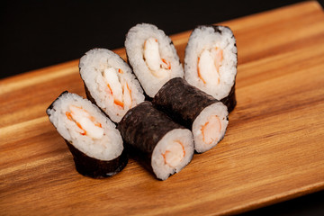 Japanese sushi maki rolls on dark background.
