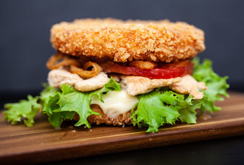 Sushi Burger with a variety of tasty ingredients on a dark background