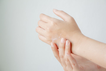 Woman hands applying hand cream moisturize the skin. The weather is cold.
